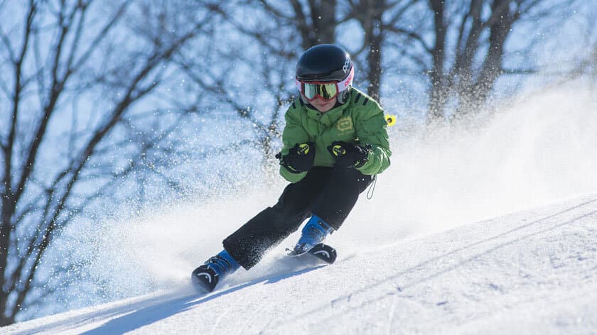 Junge bei Schussfahrt im Schnee