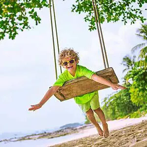 Evaneos Thailand - Kind auf der Schaukel am Strand